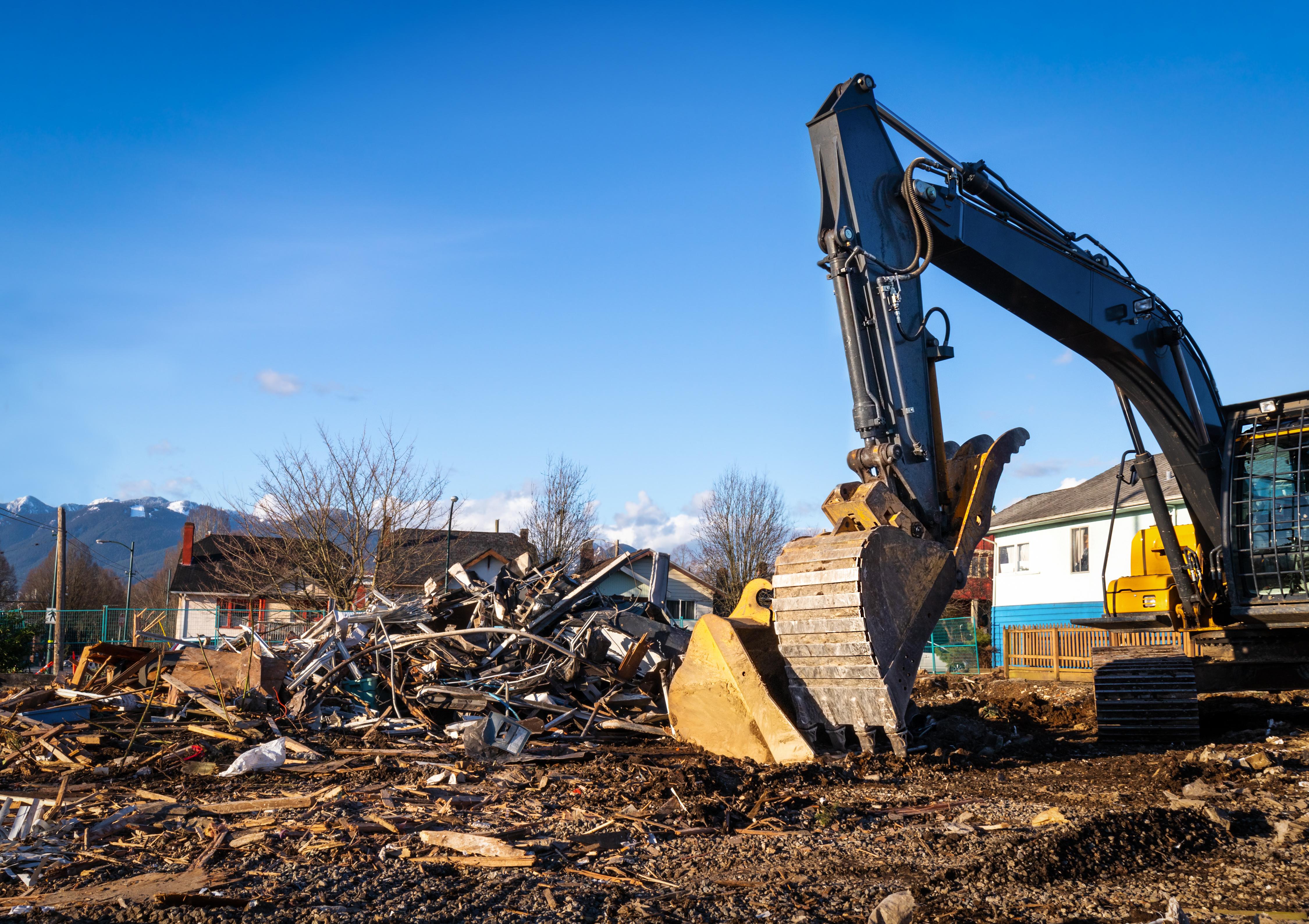 Demolition services brisbane Residential house being demolished by an excavator